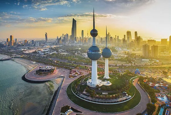 The Kuwait Towers lit up at dusk against the Kuwait City skyline.