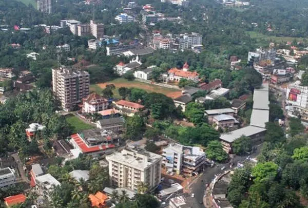 Aerial view of Thiruvalla, Kerala, with buildings set among palm groves.